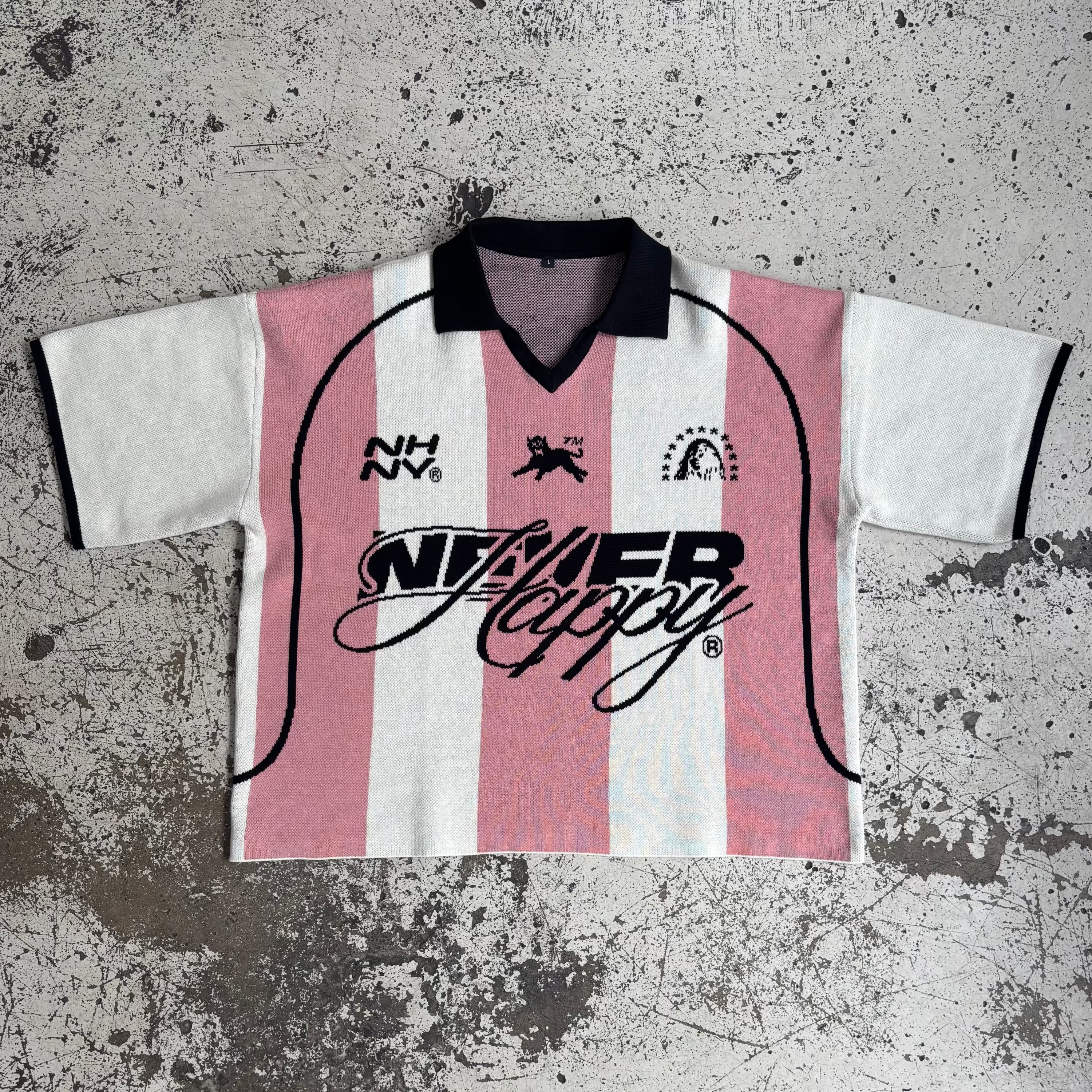 A striped sports uniform shirt with red and white colors and text on it, laid flat on a textured surface.